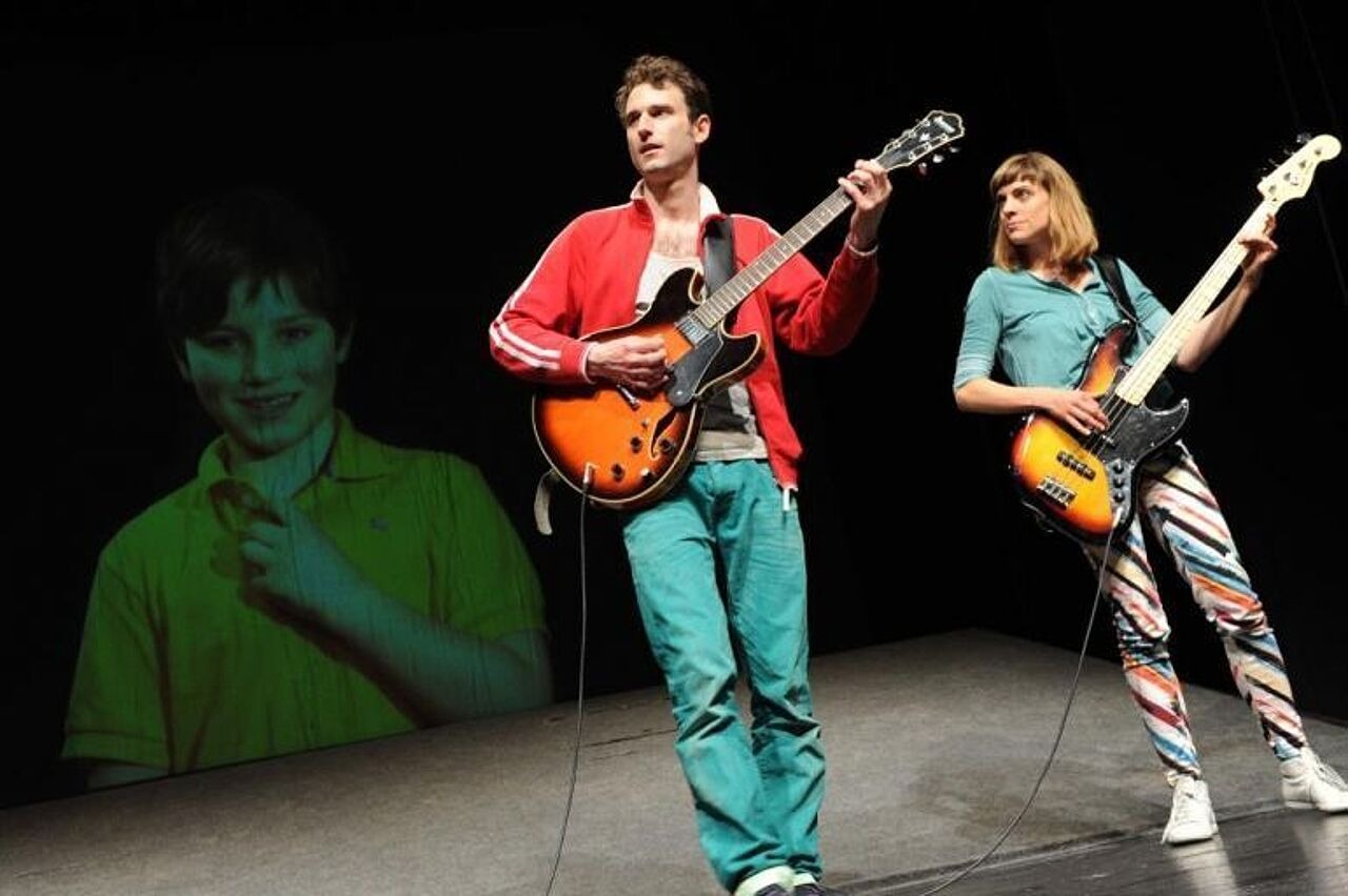 Darsteller des Theaterstücks spielen Gitarre